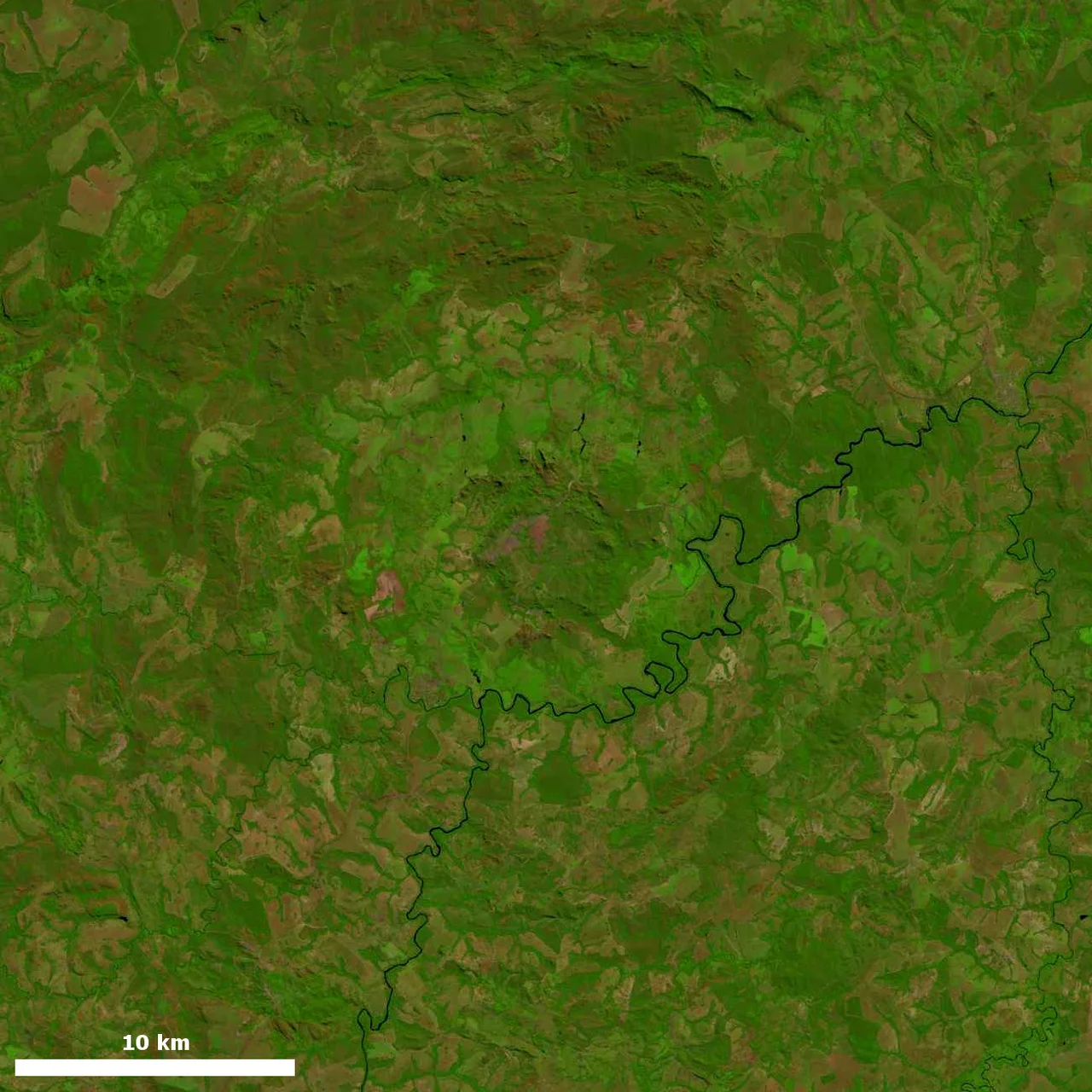 Landsat image of Araguainha crater, southern Brazil.  The Araguainha river traverses the image.  Brightness and contrast were adjusted from original.