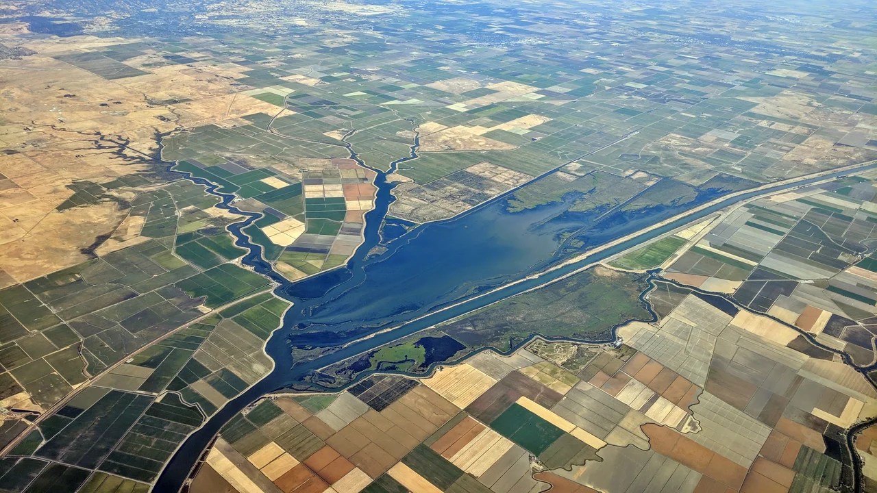Aerial view of the Sacramento River Deep Water Ship Canal and some adjoining and nearby sloughs and farm country.  Dixon and Davis are visible in the distance.