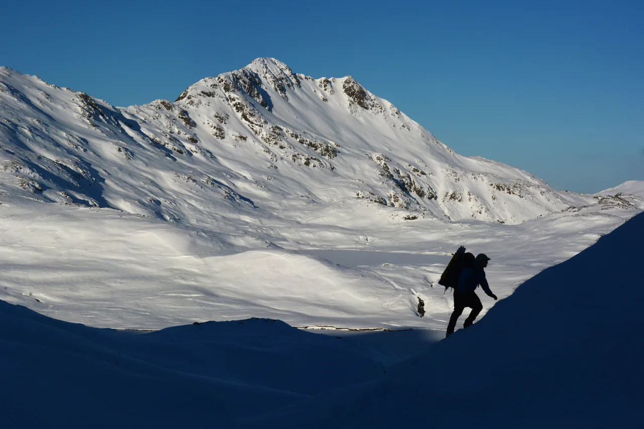 A hunter approaches a ridgeline leading to Husky Pass, on Adak Island.