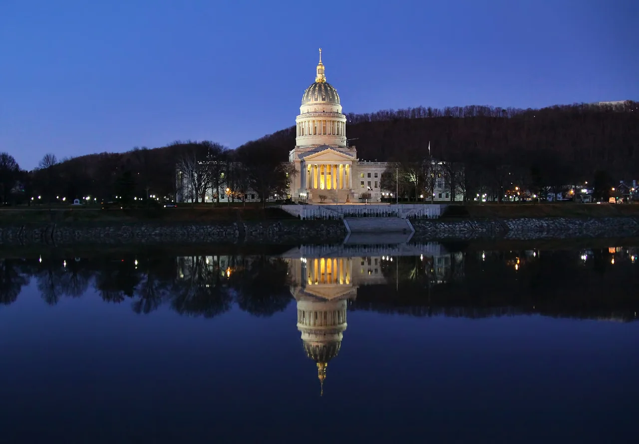 As I  was traveling through Charleston, the capital of West Virgina, during blue hour (my favorite time of day) a couple of days after Thanksgiving, I happened upon this beautiful sight of the State Capitol Building reflected in the Kanawha river flowing by in total stillness, so I just had to stop and capture the scene. I didn't have a tripod handy, so this is not a long-exposure nightshot, just a regular hand-held shot accomplished by bumping up the ISO as much as I dared to get correct exposure at acceptable shutter speed (ended up being 1/40 sec) and doing my best to keep the camera steady.