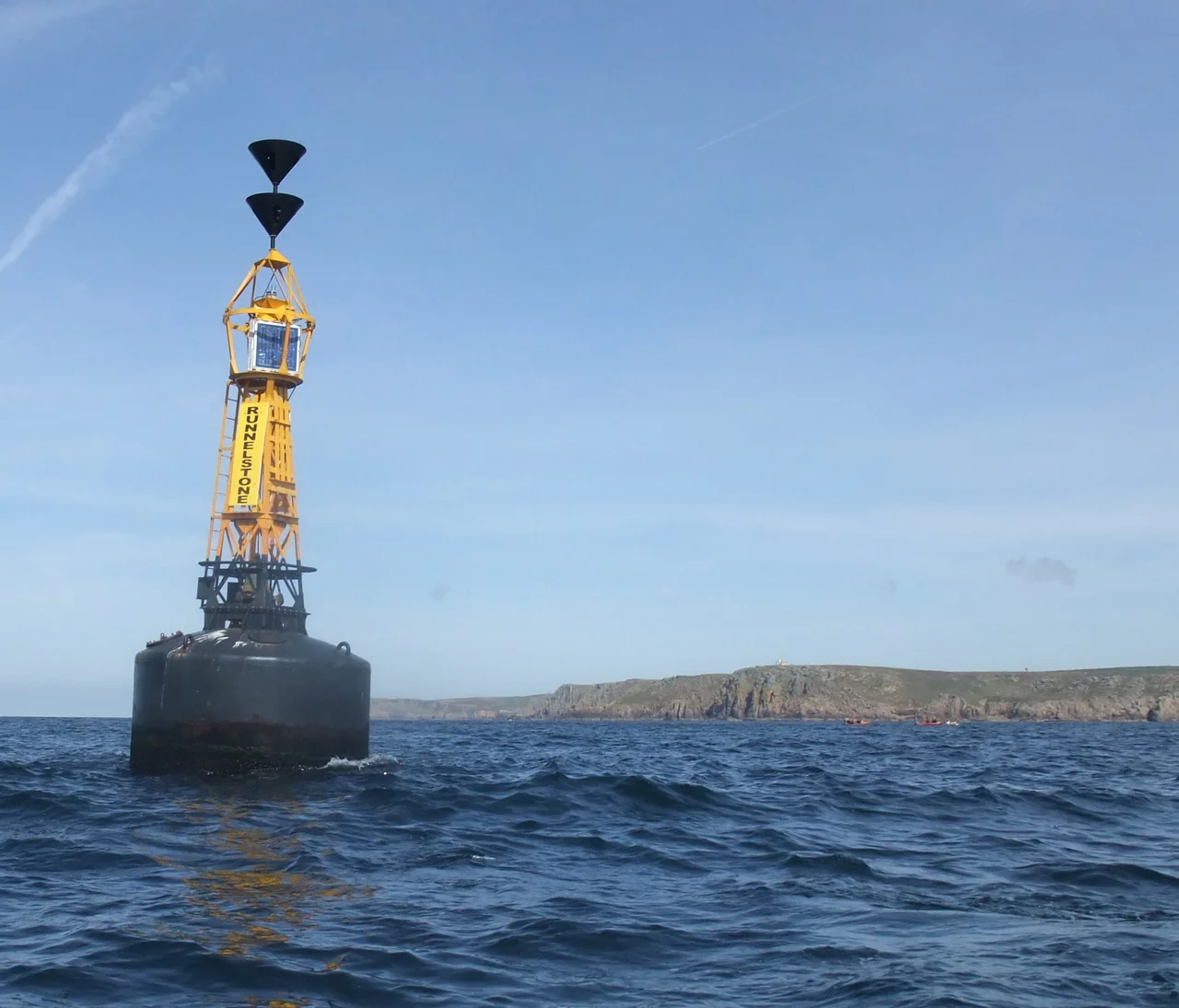 South cardinal buoy marking the Runnel Stone, near Land's End, Cornwall with dive boats visible