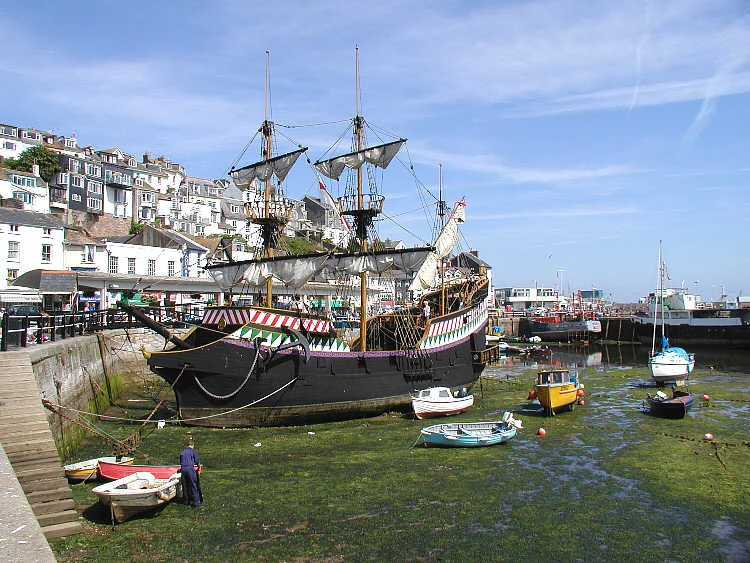 A replica of Sir Francis Drake's ship - the Golden Hind - lying permanently in Brixham Harbour. The original ship, with a crew of 80 sailors and 10 officers, circumnavigated the globe between 1577 and 1580. Five ships set out - Pelican, Elizabeth, Swan, Marigold and Benedict. During the voyage the Pelican was renamed the Golden Hind in honour of his friend Christopher Hatton whose crest featured a hind (a deer). Sir Francis brought home looted gold, silver, jewels and cash worth 25 million pounds in today's (2003) money. Only two of the ships returned, the Golden Hind and the Elizabeth. Taken by Adrian Pingstone in July 2003 and released to the public domain.