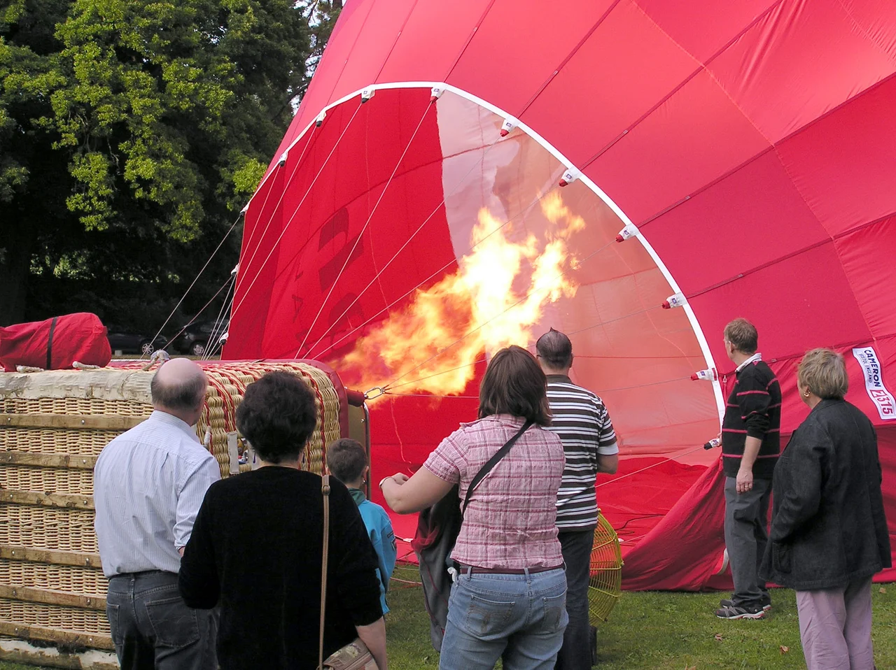 Firing the propane burners during final inflation of a hot air balloon, Royal Victoria Park, Bath, England.
This balloon carries 16 passengers and the pilot.

Photographed by Adrian Pingstone on 21st September 2005 and placed in the public domain.