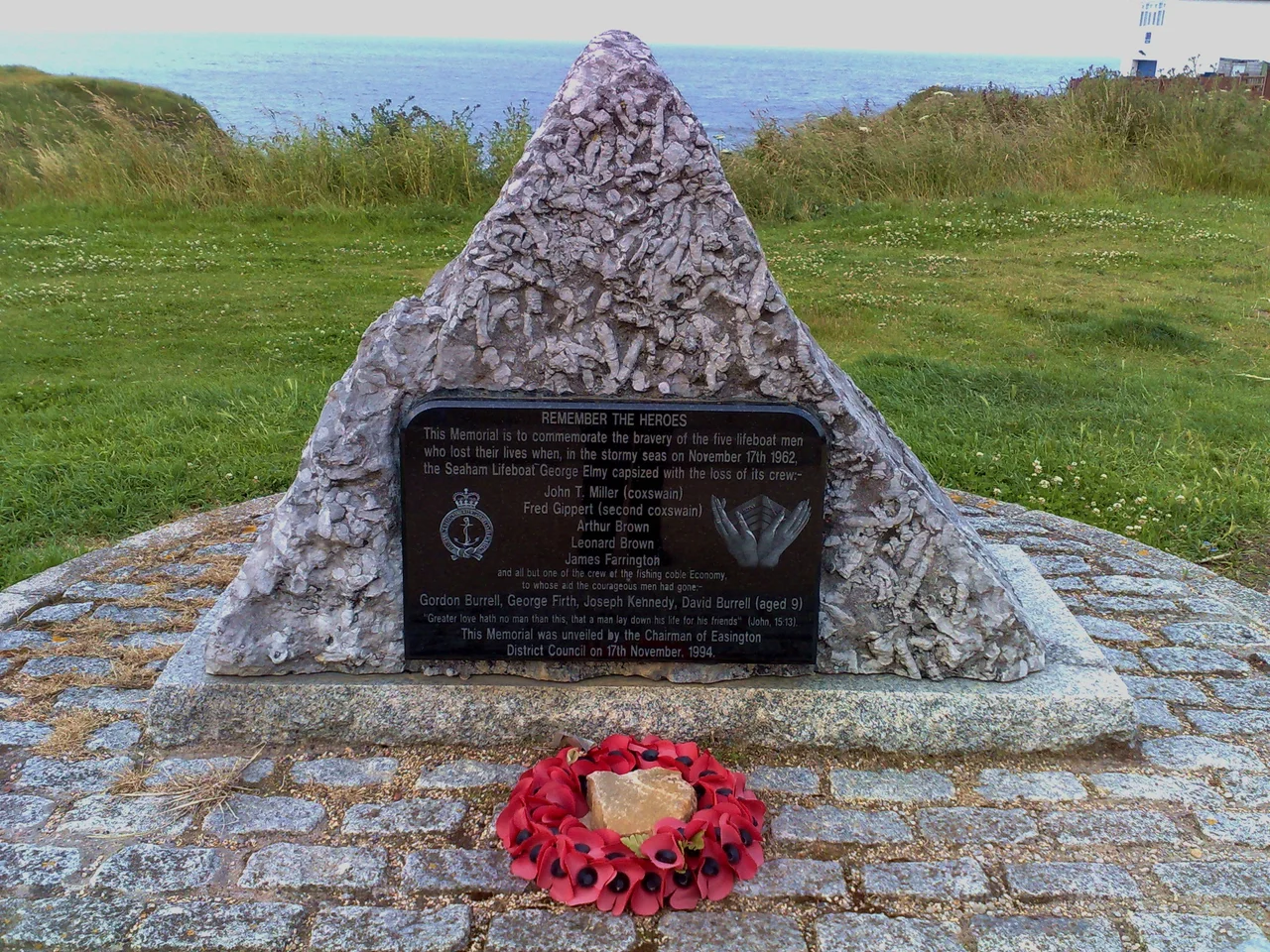 01/07/2008. Seaham, North East England, on the sea front. Google Street View
This memorial is approximately 3 foot (1m) high, commemorating the eight men and one boy who lost their lives in a storm at sea over forty years ago. The inscription reads:
REMEMBER THE HEROES
This memorial is to commemorate the bravery of the five lifeboat men who lost their lives when, in the stormy seas on November 17th 1962, the Seaham Lifeboat George Elmy capsized with the loss of its crew:
John T Miller (coxswain)
Fred Gippert (second coxswain)
Arthur Brown
Leonard Brown
James Farrington
and all but one of the crew of the fishing coble Economy, to whose aid the courageous men had gone:
Gordon Burrell, George Firth, Joseph Kennedy, David Burrell (aged 9)
"Greater love hath no man than this, that a man lay down his life for his friends" (John, 15:13).
This memorial was unveiled by the Chairman of Easington District Council on 17th December, 1994.
More information is available on the official website.
UPDATE (May 09): Also this recent article in the Sunderland Echo - the George Elmy has come home to Seaham! See David John Harris' photograph of her just after she arrived.
UPDATE: (Jan 10): Restoration of the George Elmy is under way.

Once completed, she will be allowed to complete the journey she started so many years ago; sailing into the harbour one last time, before taking pride of place as the main exhibit in the newly refurbished North Dock.