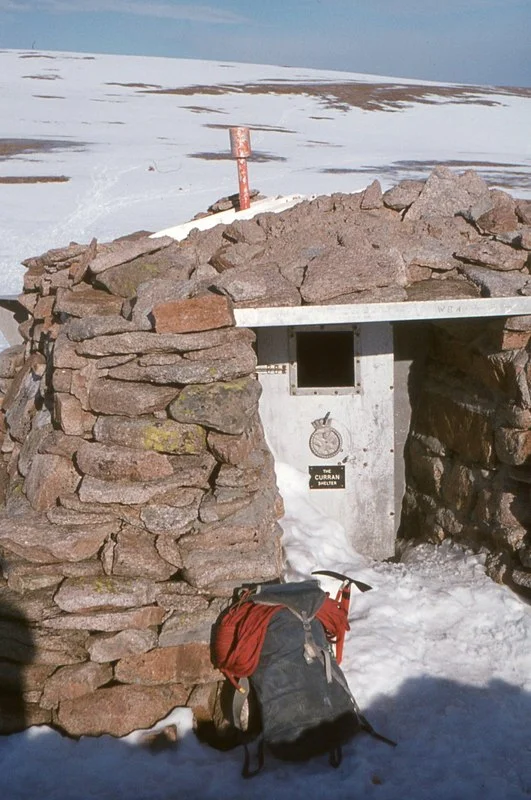 Curran Bothy, Cairngorm Plateau This small stone-built shelter was the overnight destination for two school groups on a mountaineering expedition on 19th November 1971. One group arrived in deteriorating weather, but the others could not find it in bad visibility and blowing snow. They bivouaced but after a second night out, only two survivors were found by rescue teams. The remaining five schoolchildren and an 18-year-old student teacher died.
A few years later, this and some other high-level shelters were removed.
On this visit in 1975, the shelter was part filled with snow which had either come through the doorway or chinks in the walls. In heavy snow years, the whole structure could be buried, with only the chimney protruding from the surface.