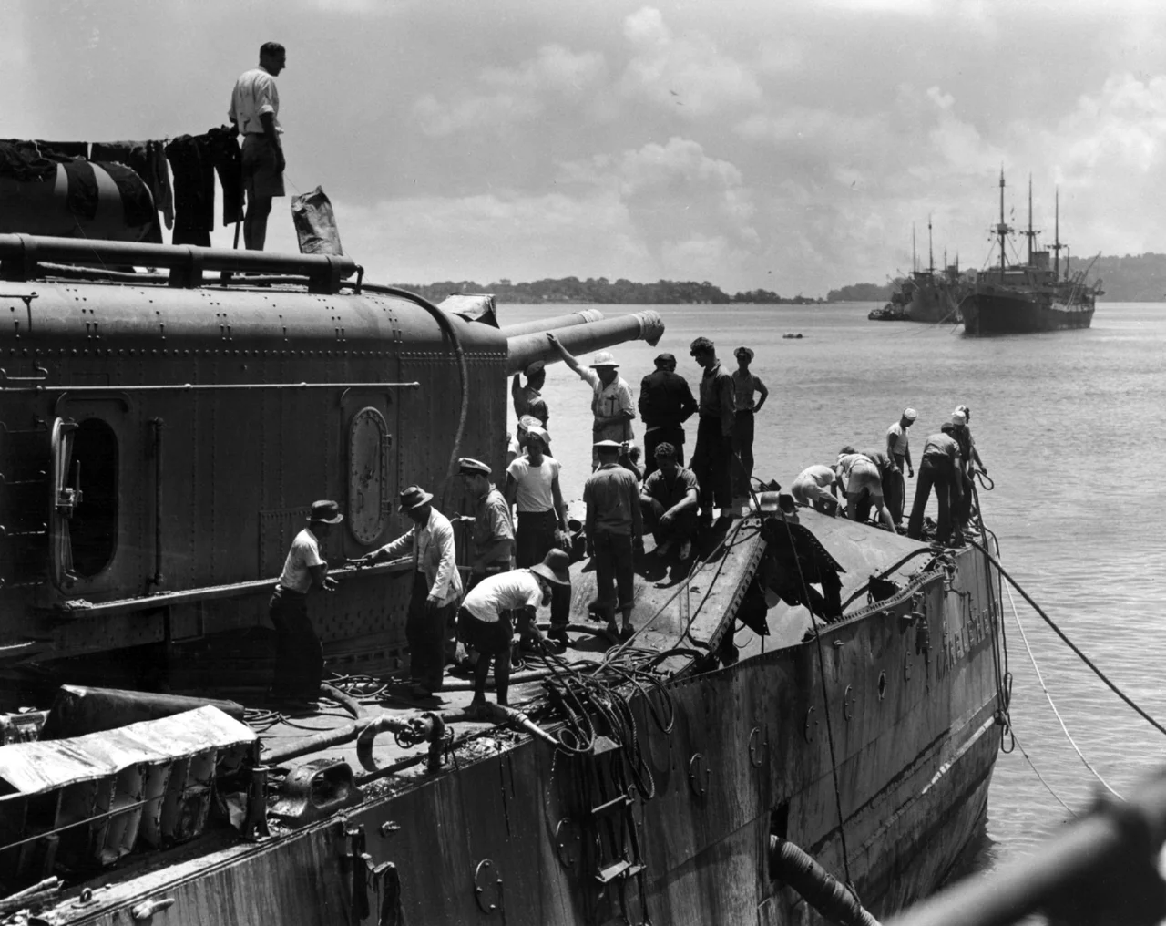 The U.S. Navy light cruiser USS Marblehead (CL-12) at Tjilatjap, Java, in February 1942, after she had been damaged by Japanese high-level bombing attack in the Java Sea on 4 February 1942 in the Battle of Makassar Strait. This view shows the effect of an enemy bomb which struck her stern. Her after 6"/53 gun turret is at left. Note the blanked off portholes on her hull side.