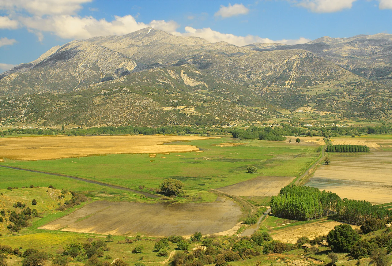 de:Stymfalia, limni / lake / See; Peloponnese, May 2006
Blickrichtung nord: Dorf Stymfalia, Ziria-Gebirge. Vordergrund: Felder noch reilweise überflutet; Wassergraben unmittelbar vor Hadrian-Tunnel, Seegrenze.

View north: Village Stymfalia, Mountain Ziria. Foreground: flooded fields, drainage trench enters Hadrin tunnel.