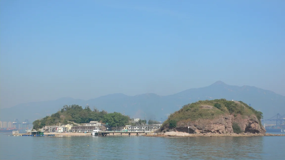 Ap Chau, an outlying island in Northern District in Hong Kong. The mountains and the port facilities in the background are in Shenzhen.