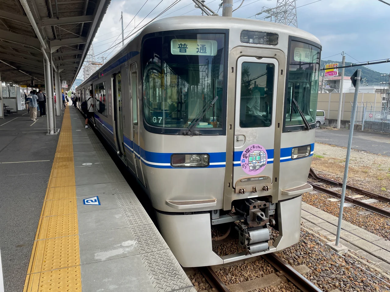 高蔵寺駅にとまる愛知環状線の電車。ヘッドマークに「ジブリパーク愛環で来てね」と書いてある。